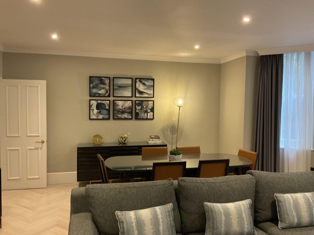Living room with grey sofa, dining table and framed black-and-white artwork