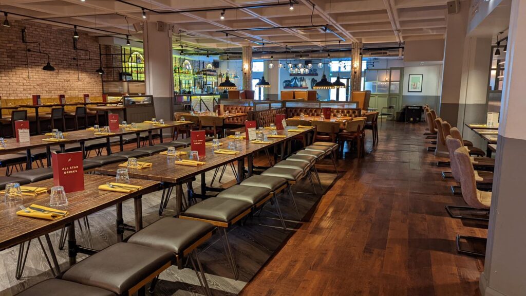 Restaurant with long communal tables, benches and timber floor